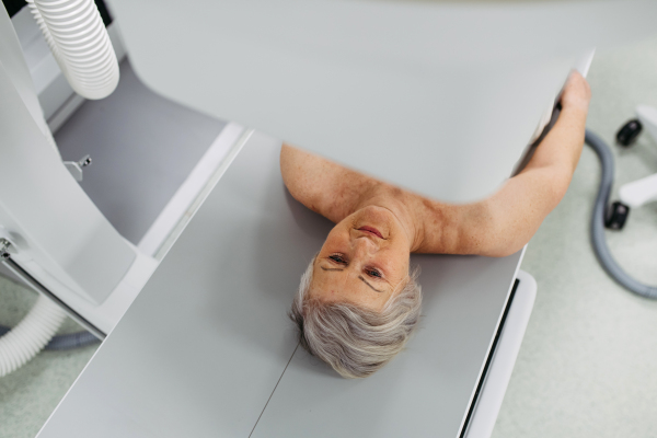 Senior patient undergoing X-ray on tilting wall unit