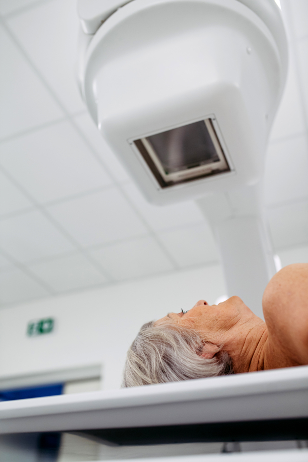 Senior patient undergoing X-ray on tilting wall unit