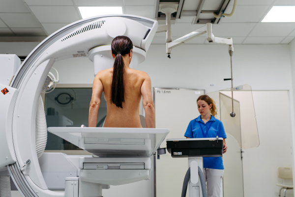 Female patient preparing for diagnostic imaging with modern X-ray system