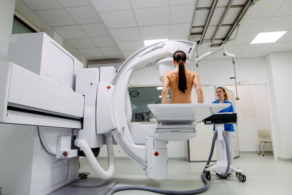 Female patient preparing for diagnostic imaging with modern X-ray system