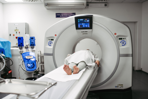 Senior patient undergoing head CT scan with laser alignment active