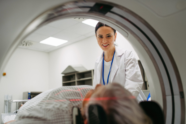 Medical professional guiding patient into position for CT head exam