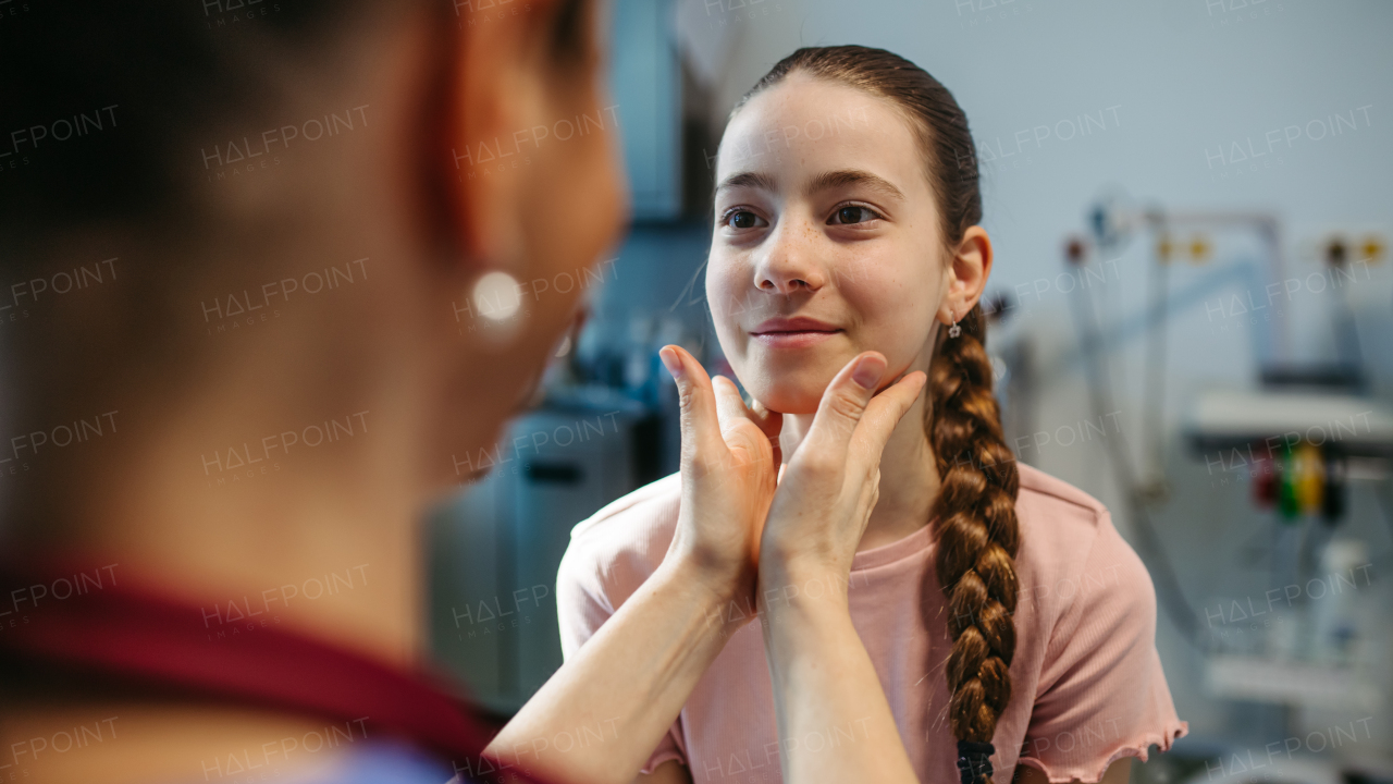 Pediatrician palpating lymph nodes during routine health check.