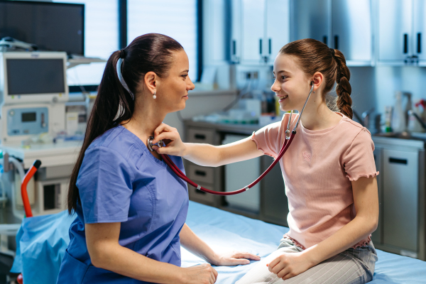 Girl patient listening to doctor heartbeat with stethoscope.