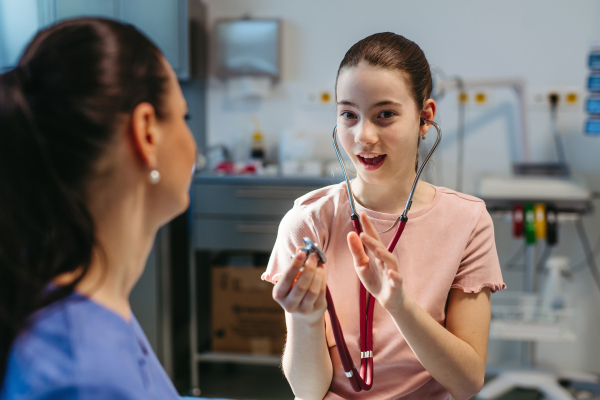 Doctor uses stethoscope play to ease young patient's nerves.
