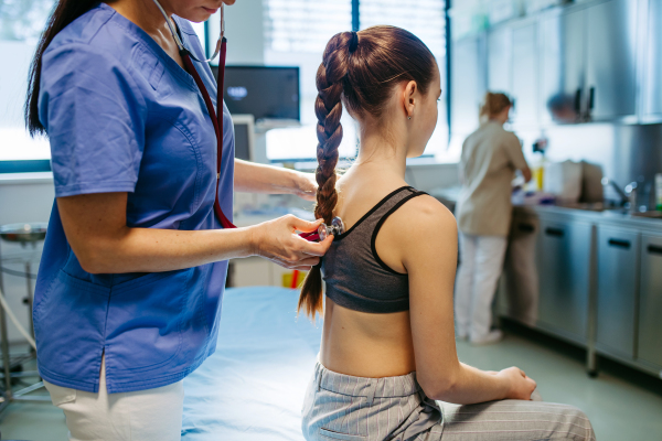 Preventive spinal screening of school-aged child at clinic.