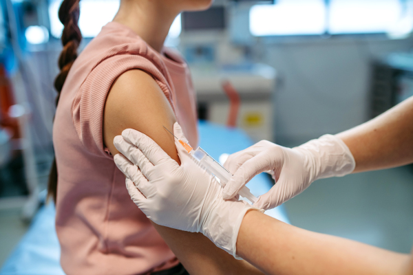 Close-up of vaccine injection for young girl in doctor's office