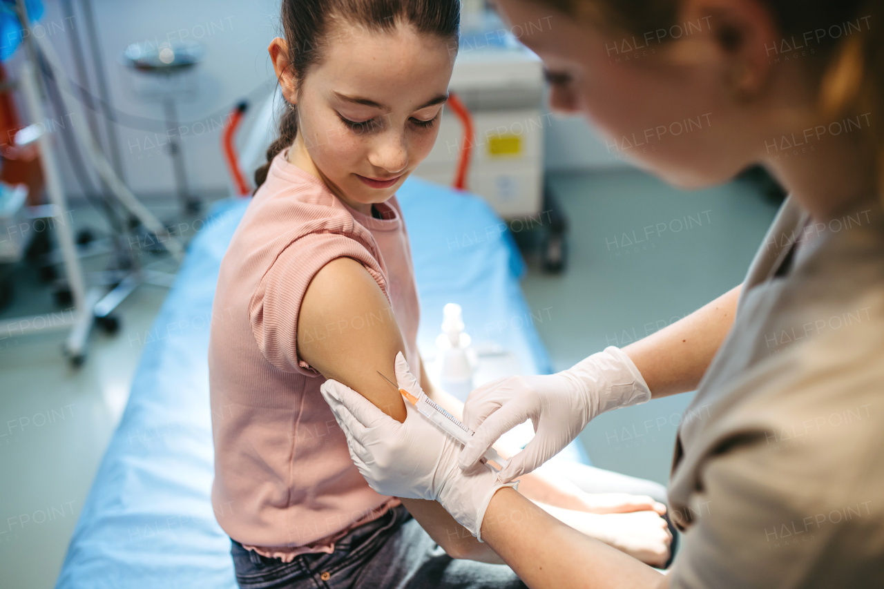 Child getting vaccinated during medical exam at pediatric clinic.