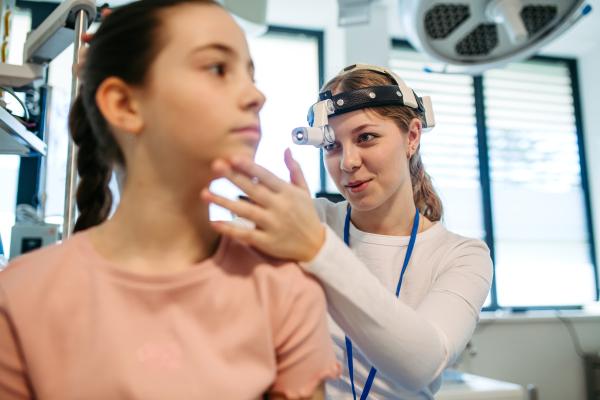 Ear examination of a young girl at a medical clinic.