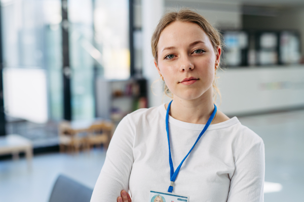 Portrait of female doctor standing in hospital hallway.