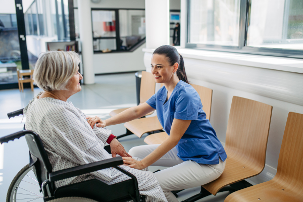 Doctor and elderly patient having conversation in hospital setting