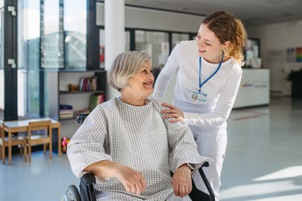 Compassionate healthcare worker interacting with elderly patient in wheelchair