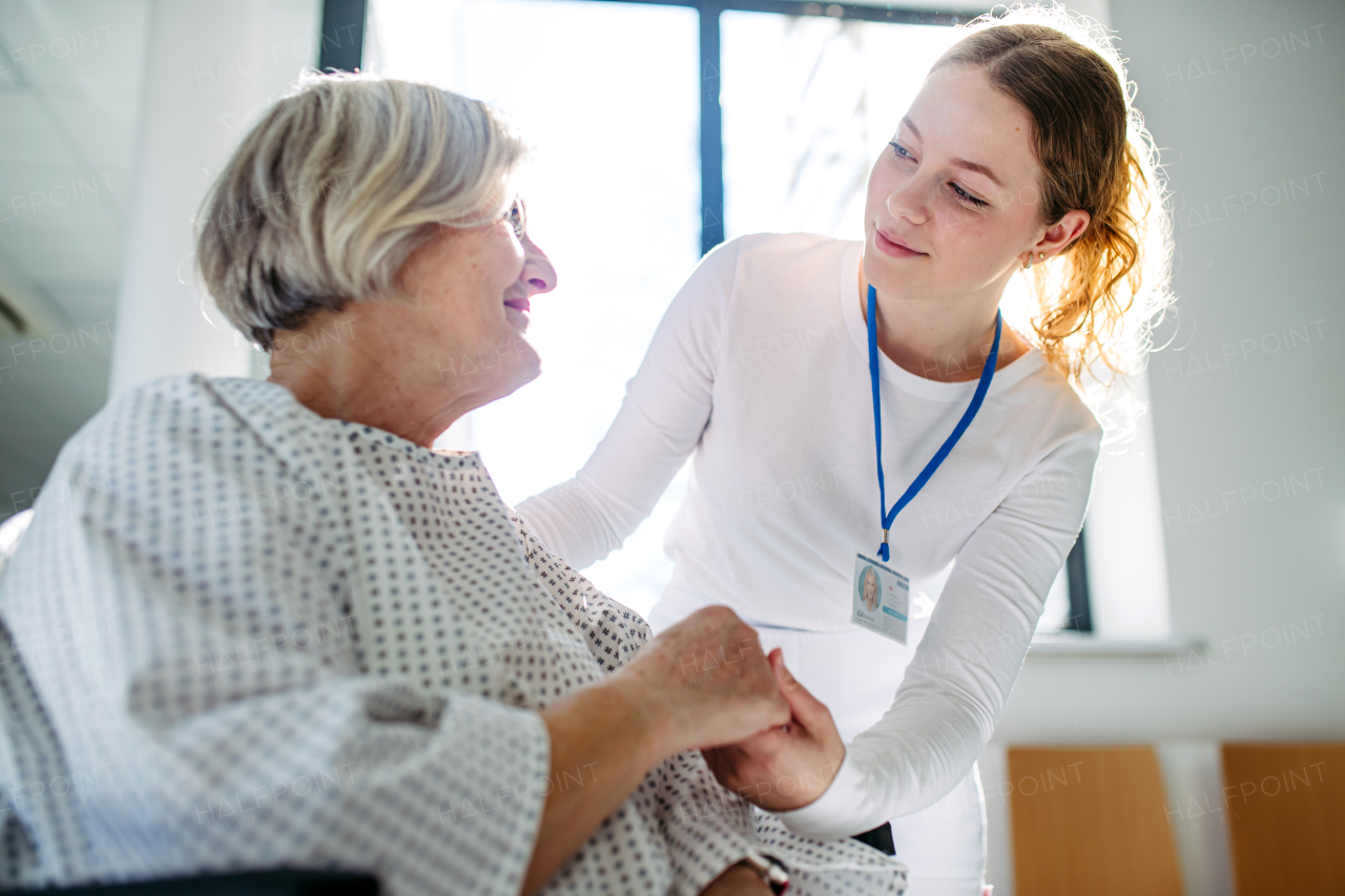 Compassionate healthcare worker interacting with elderly patient in wheelchair