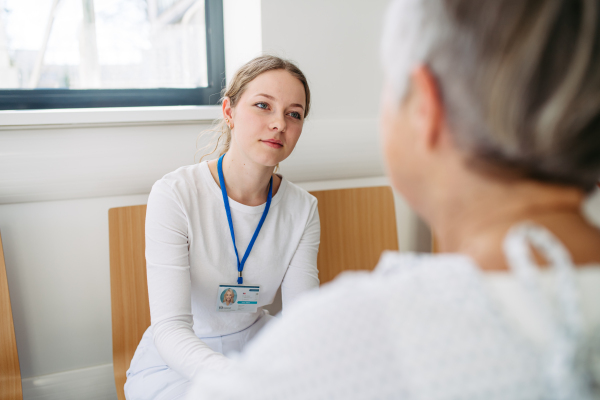 Compassionate healthcare worker interacting with elderly patient in wheelchair