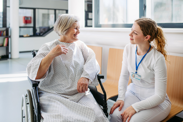 Doctor and elderly patient having conversation in hospital setting