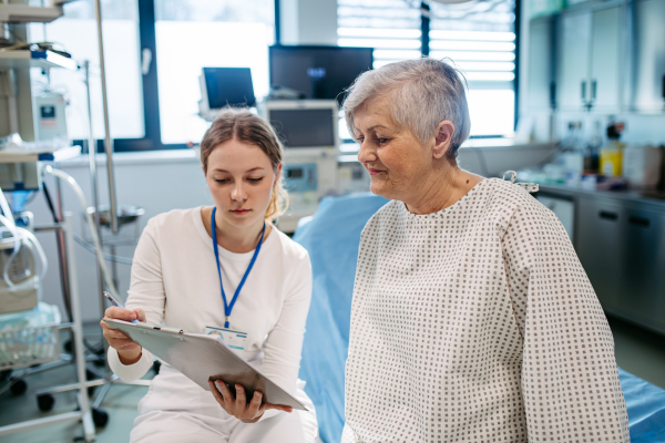 Geriatrician talking with senior patient during check-up. Medical consultation.