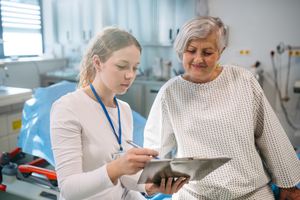 Geriatrician talking with senior patient during check-up. Medical consultation.