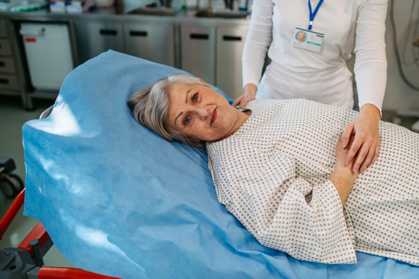 Scared elderly patient lying in hospital bed