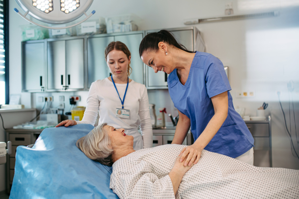 Doctor comforting elderly patient in hospital bed