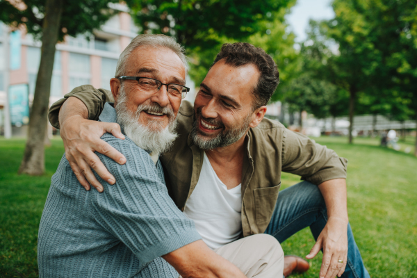 Portrait of handsome mature man and his older father hugging each other. Fathers day concept.