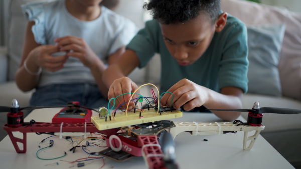 Kids building their first homemade robot at home. Educational robotic kit for children.