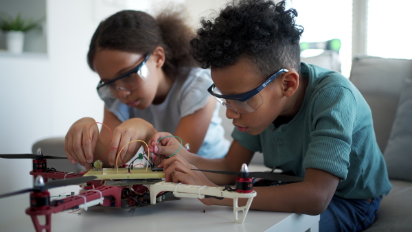 Kids building their first homemade robot at home. Educational robotic kit for children.