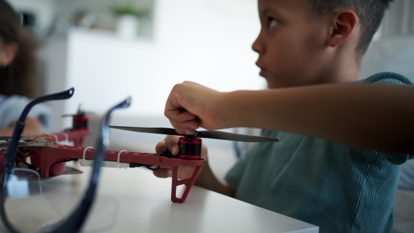 Close up of kids building their first homemade robot at home. Educational robotic kit for children.