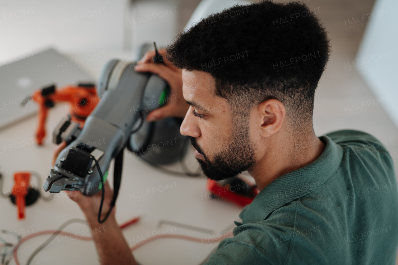 Engineering student creating and calibrating a robotic arm during a home robotics session.