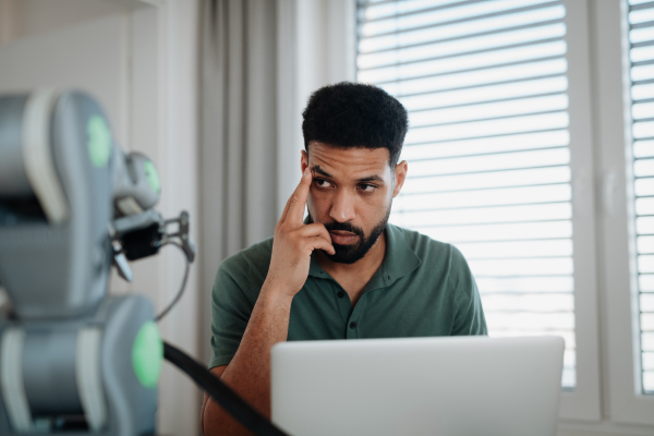 Engineer struggling with a technical problem while building robotic arm at home.