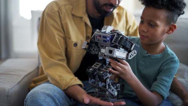 Father teaching son about STEM, robotics, and discussing technology at home.