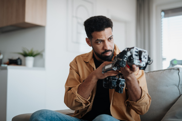 Handsome engineer student working on robot project at home. Robotics concept.