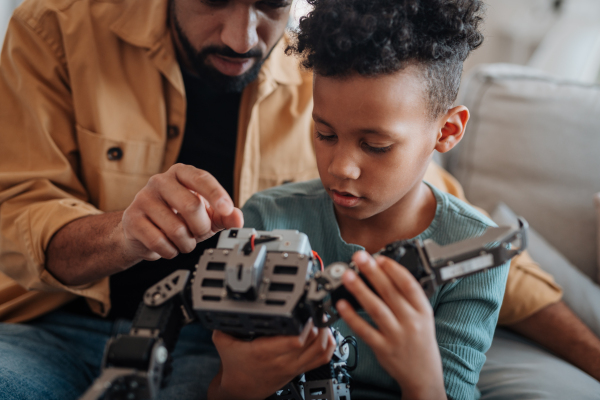 Father and son exploring STEM, robotics, and technology together at home
