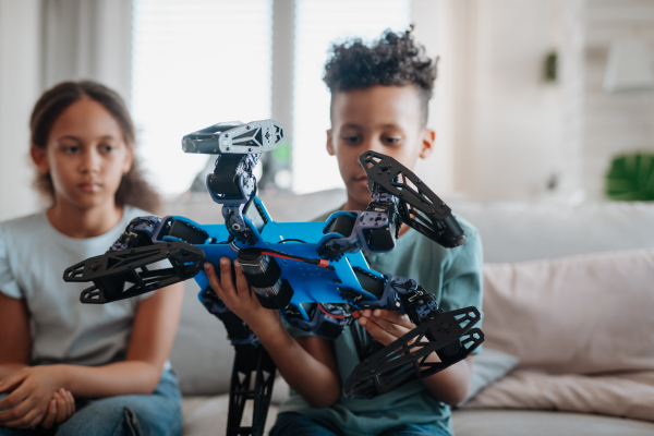 Kids playing with drone at home. Educational robotic kit for children.