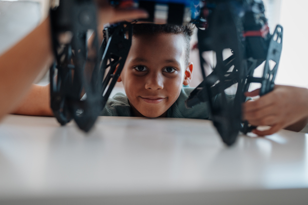 Focused boy building and programming robot car at home as part of STEM learning.