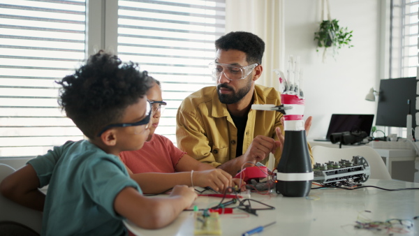 Father teaching kids about STEM, robotics, and discussing technology at home.