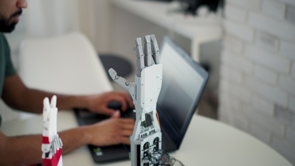 Young engineer building and programming a robotic arm at home. Robotics concept.