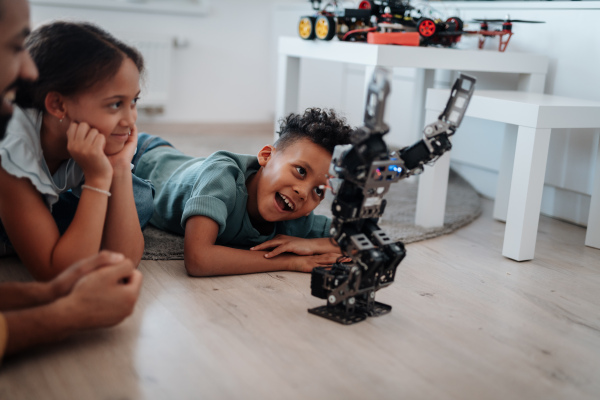 Father teaching kids about STEM, robotics, and discussing technology at home.