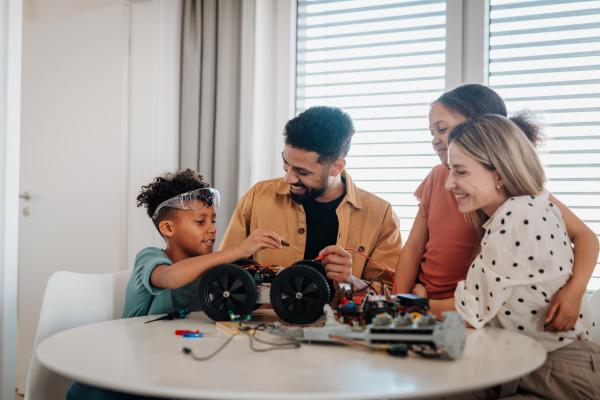 Parents encouraging their children to explore robotics and technical skills.
