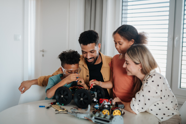 Parents encouraging their children to explore robotics and technical skills.
