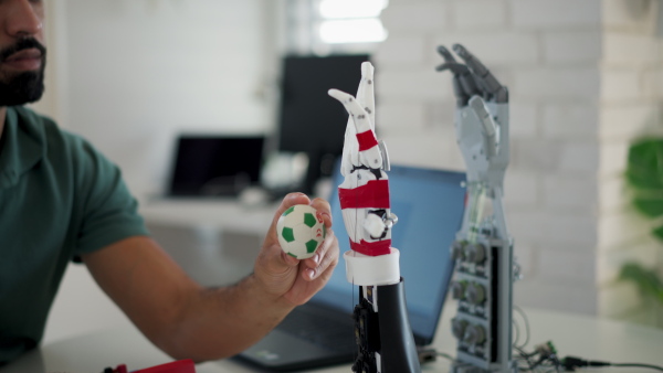 Young engineer building and programming a robotic arm at home. Robotics concept.