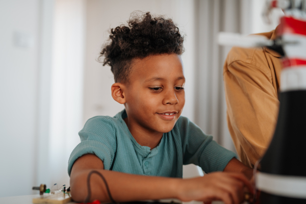 Father and son exploring STEM, robotics, and technology together at home