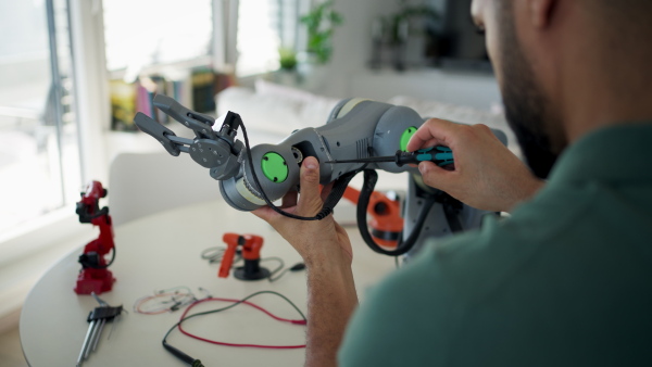 Engineer struggling with a technical problem while building robotic arm at home.