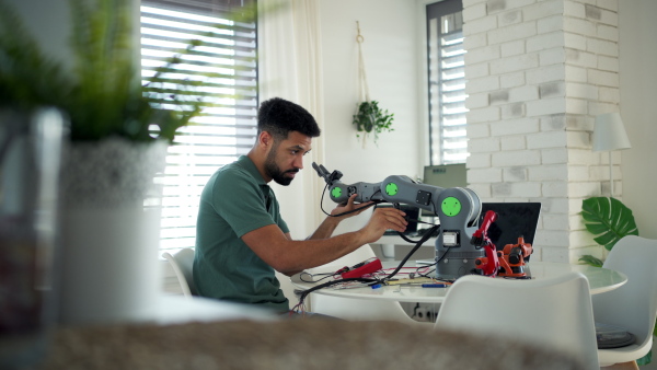Engineer struggling with a technical problem while building robotic arm at home.