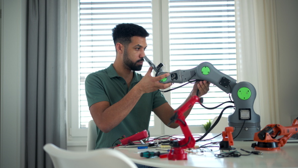 Engineer struggling with a technical problem while building robotic arm at home.
