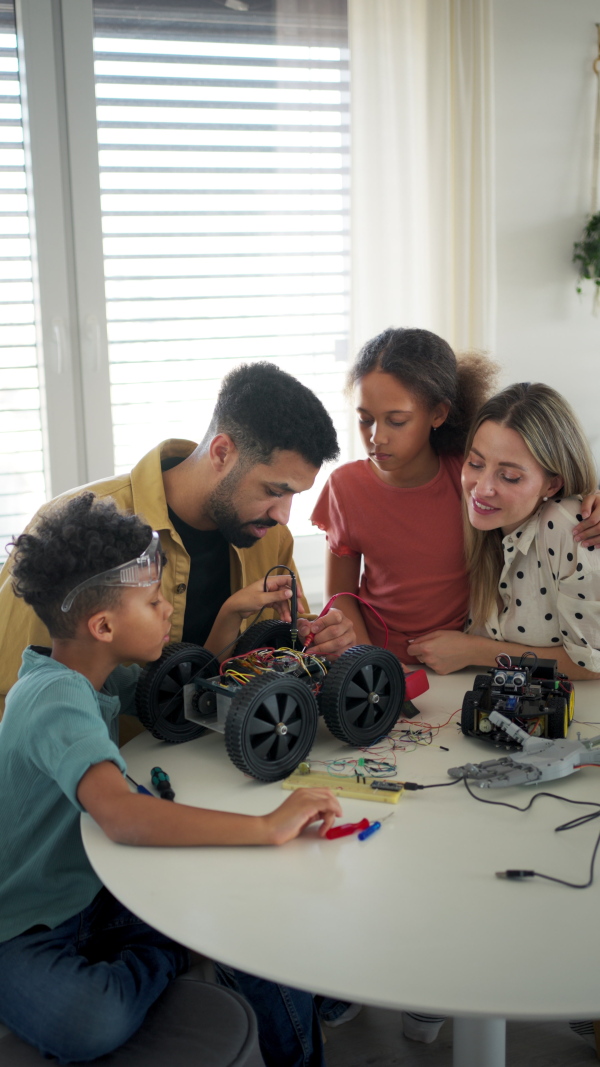 Parents encouraging their children to explore robotics and technical skills.