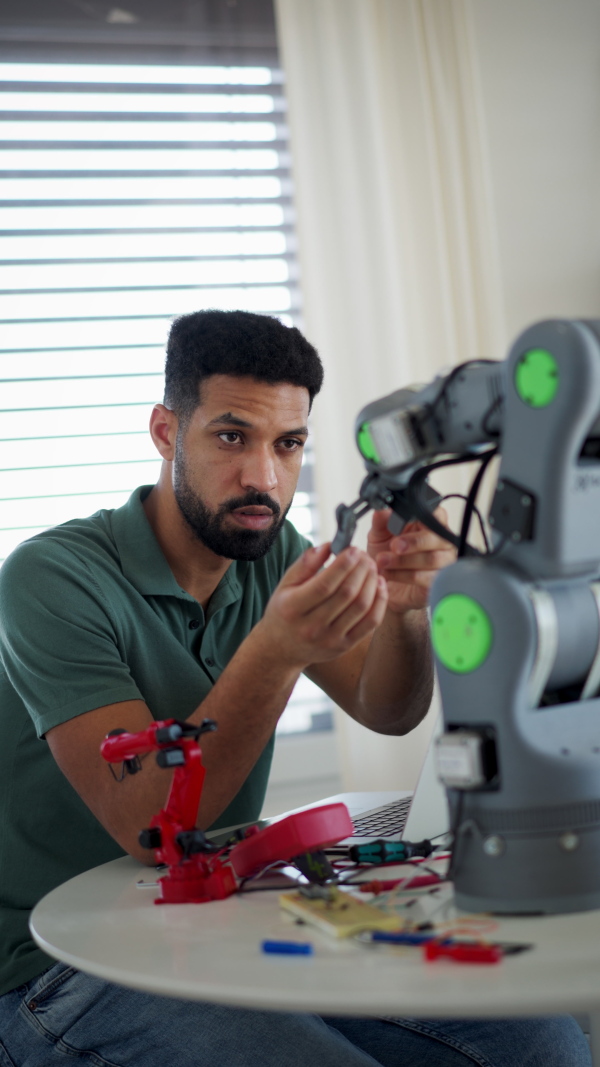 Engineer struggling with a technical problem while building robotic arm at home.
