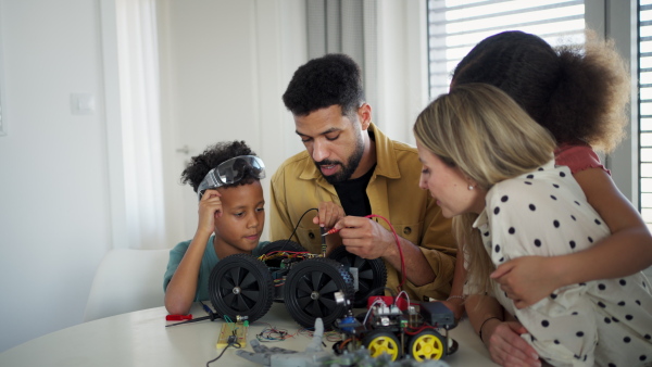 Parents encouraging their children to explore robotics and technical skills.