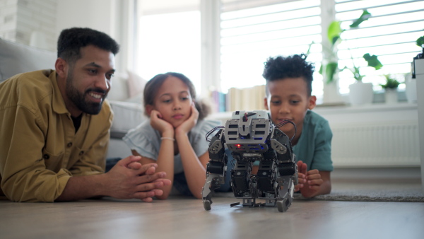 Father teaching kids about STEM, robotics, and discussing technology at home.