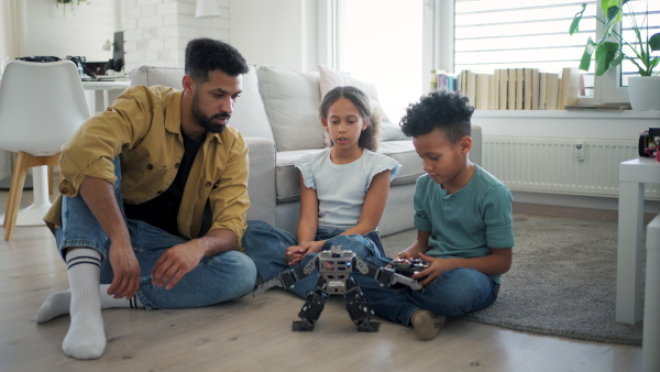 Father teaching kids about STEM, robotics, and discussing technology at home.