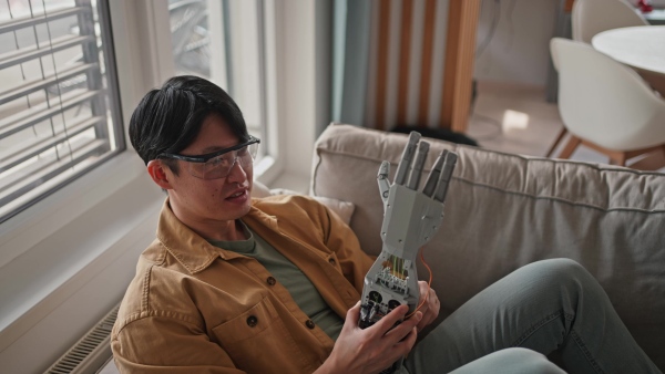 Young engineer building a robotic arm at home. Robotics concept.
